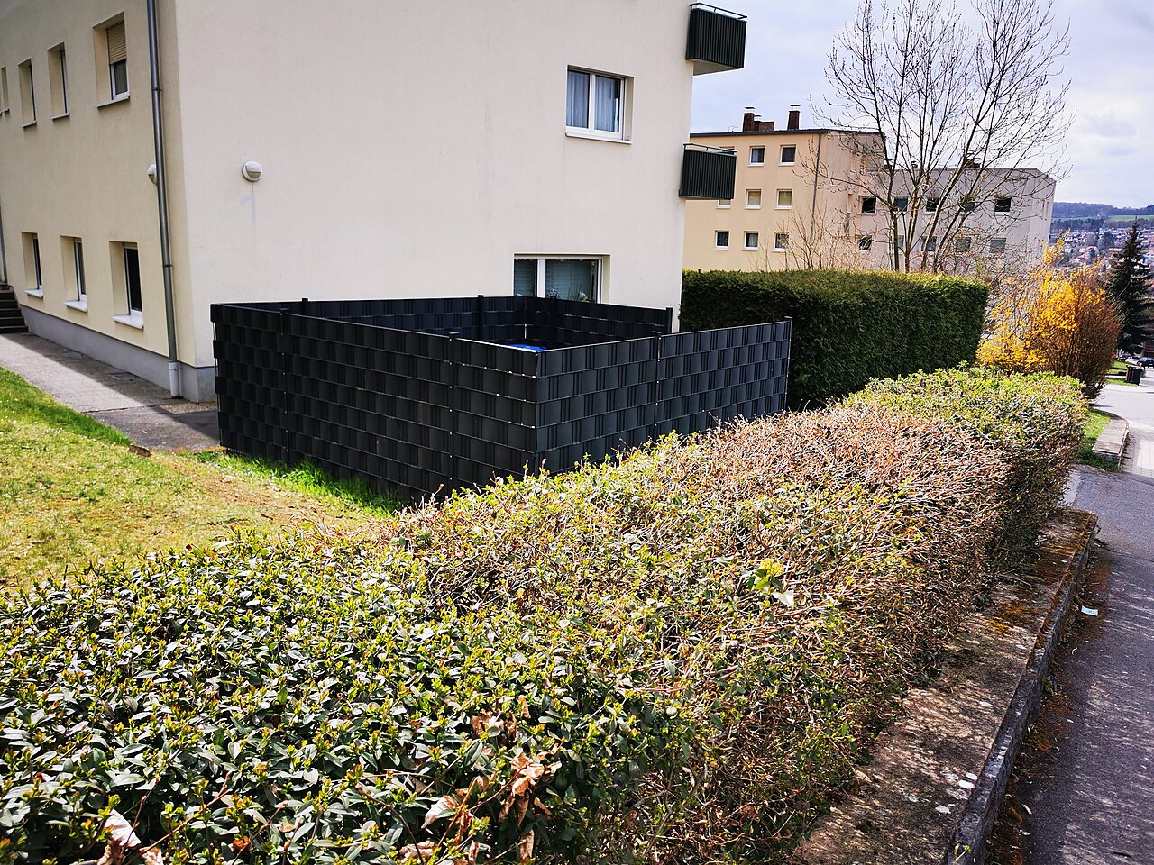 Beispielfoto eines dunklen Stabmattenzauns mit eingeflochtenen Sichtschutzstreifen